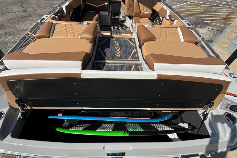 Slide: The Image of 2025 Tigé Ultré 25ZX boat interior with tan seating and surfboard storage. - 56