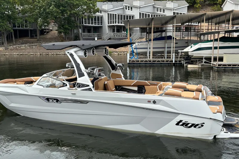 Slide: The Image of 2025 Tigé Ultré 25ZX boat on trailer, sleek design, sunny day background. - 6