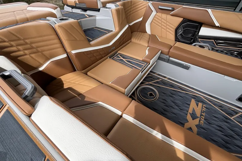 Slide: The Image of 2025 Tigé Ultré 25ZX boat interior with tan and white seating, stylish deck design. - 8