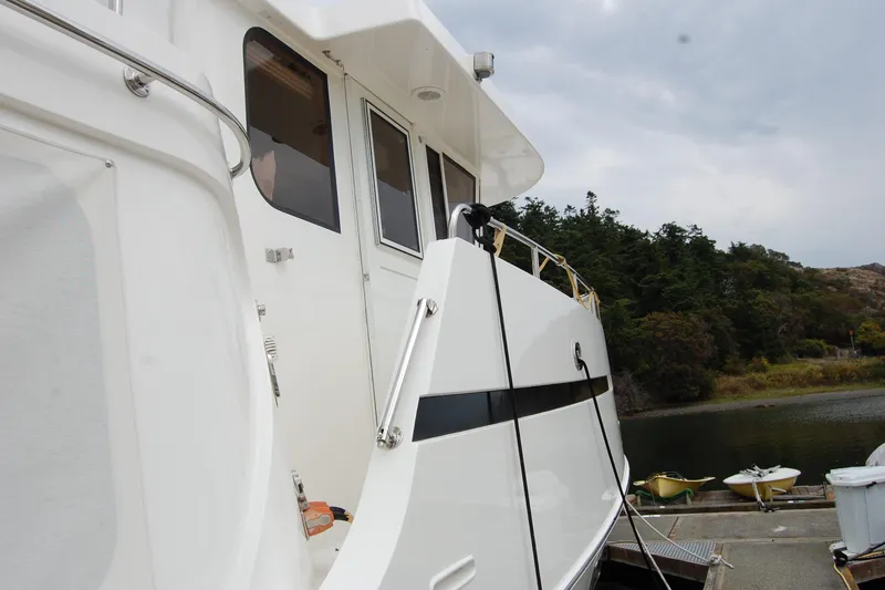 Slide: The Image of 2001 Ocean Alexander Classico yacht docked near lush greenery and calm waters. - 10