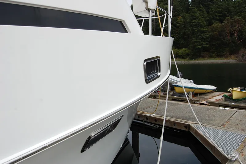 Slide: The Image of 2001 Ocean Alexander Classico yacht docked at a marina with lush forest backdrop. - 11
