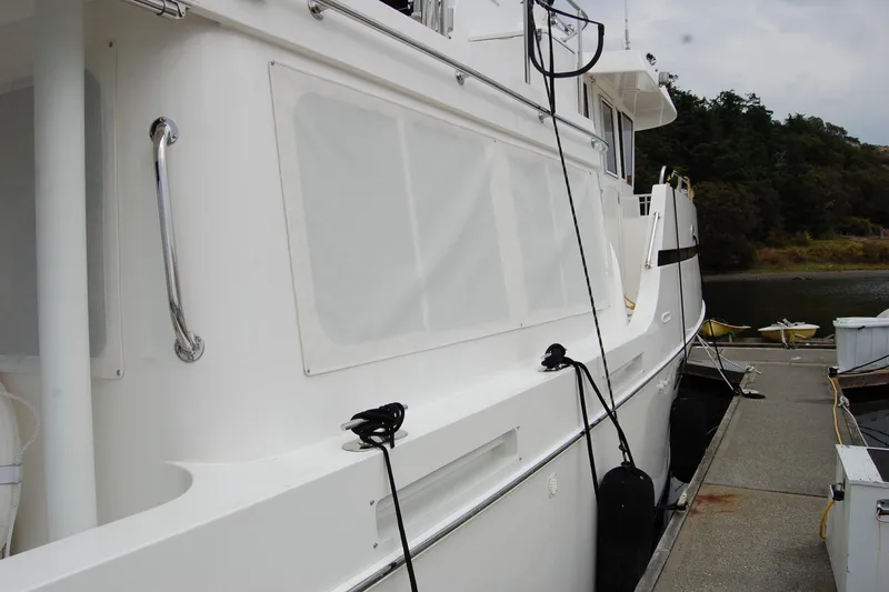 Slide: The Image of 2001 Ocean Alexander Classico yacht docked at marina, side view with white exterior. - 14