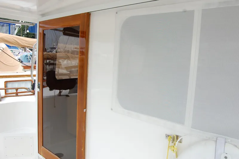 Slide: The Image of 2001 Ocean Alexander Classico yacht with wooden door and white exterior. - 18
