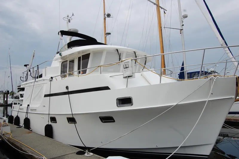 Slide: The Image of 2001 Ocean Alexander Classico yacht docked at marina, showcasing sleek white design. - 2