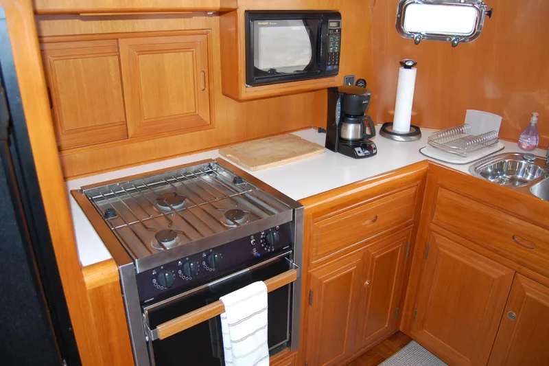 Slide: The Image of Galley kitchen in 2001 Ocean Alexander Classico yacht with stove, microwave, and coffee maker. - 28