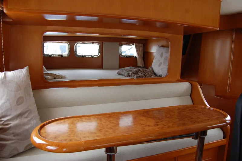 Slide: The Image of 2001 Ocean Alexander Classico yacht interior with wooden table and cozy seating area. - 42