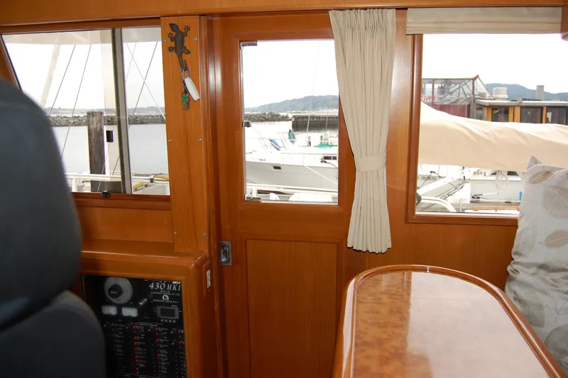 Slide: The Image of Interior view of 2001 Ocean Alexander Classico yacht with wooden finish and marina backdrop. - 46