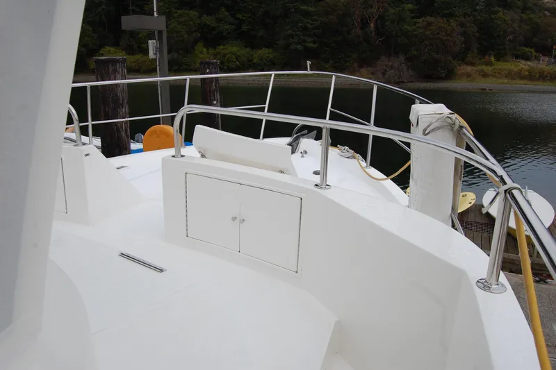Slide: The Image of Ocean Alexander Classico 2001 yacht deck with railing, docked by a serene waterway. - 61