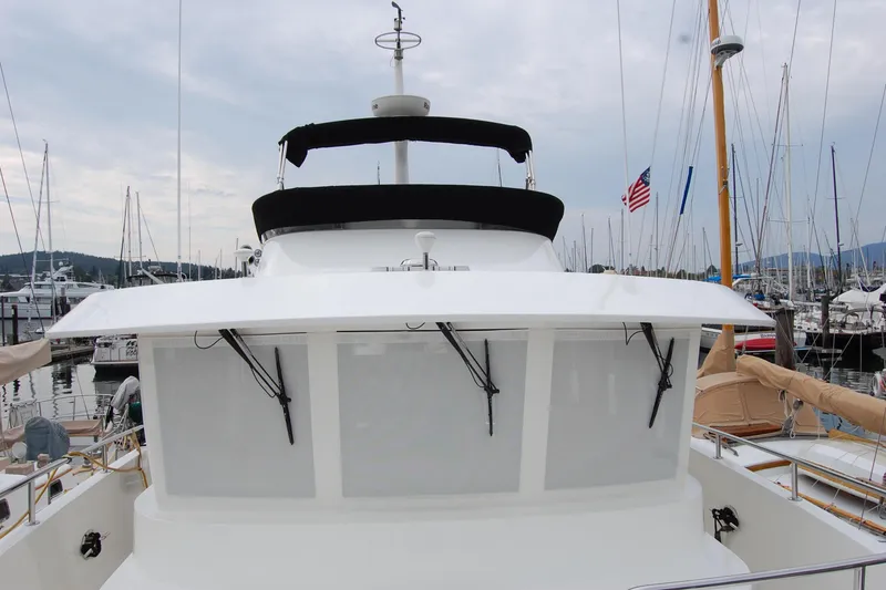 Slide: The Image of 2001 Ocean Alexander Classico yacht docked at marina with American flag in background. - 62