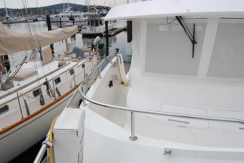 Slide: The Image of 2001 Ocean Alexander Classico yacht docked at marina, featuring sleek white design and railing. - 63