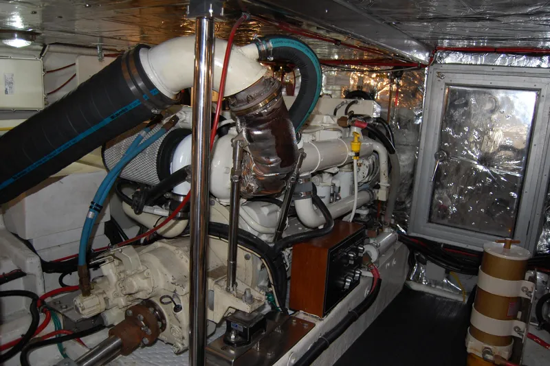 Slide: The Image of Engine room of 2001 Ocean Alexander Classico yacht, showcasing mechanical components and piping. - 75