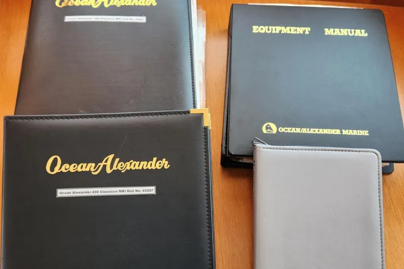 Slide: The Image of Manuals and folders for 2001 Ocean Alexander Classico yacht on wooden surface. - 81