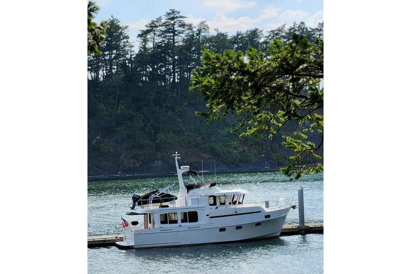 Slide: The Image of 2001 Ocean Alexander Classico yacht docked by a scenic forested shoreline. - 83