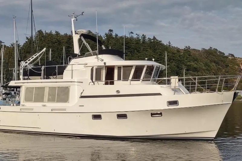 Slide: The Image of Ocean Alexander Classico 2001 yacht docked, surrounded by trees and calm water. - 84