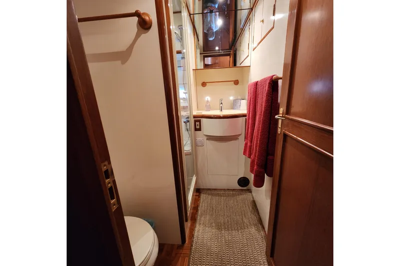 Slide: The Image of Bathroom interior of 2001 Ocean Alexander Classico yacht with wooden accents and red towels. - 93
