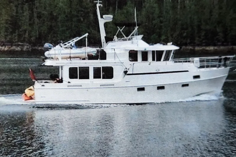 Slide: The Image of Ocean Alexander Classico 2001 yacht cruising on a calm waterway with forested background. - 94