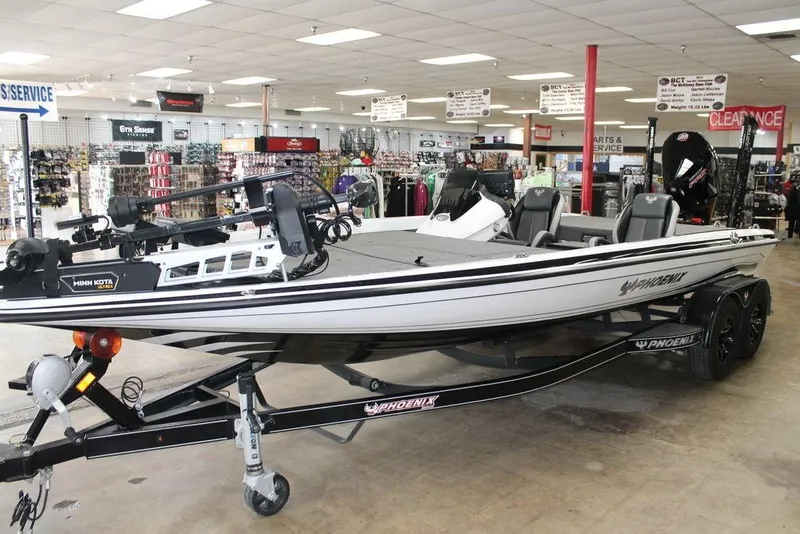 Slide: The Image of 2024 Phoenix 921 Elite II boat displayed in a showroom with fishing equipment. - 6