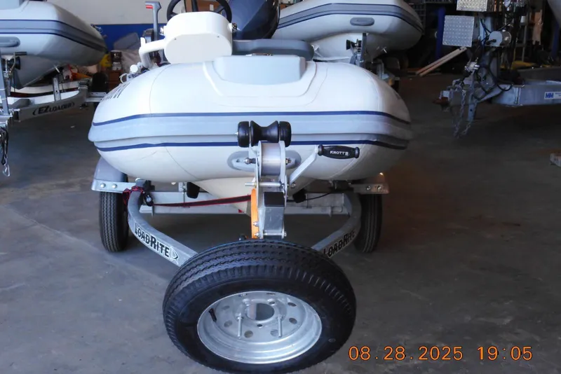 Slide: The Image of 2024 Highfield CL310 inflatable boat on trailer in a garage setting. - 2