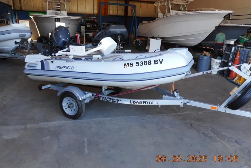 The Image of 2024 Highfield CL310 inflatable boat on trailer in a garage setting. - 1