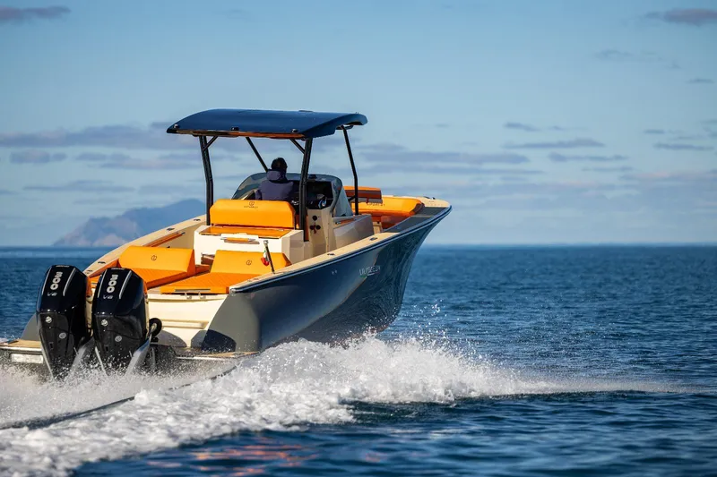 Slide: The Image of 2025 AlCustom LIPARI 31 boat cruising on open water, featuring dual engines. - 2