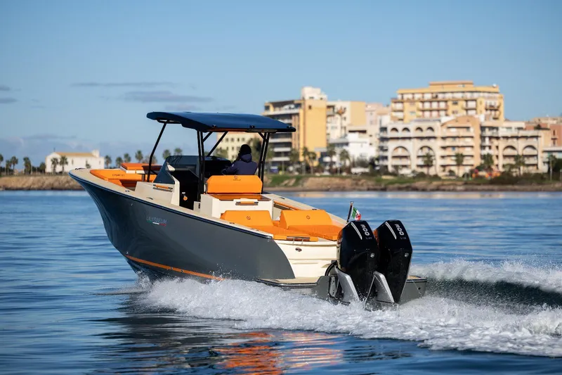 Slide: The Image of 2025 AlCustom LIPARI 31 boat cruising on calm water near coastal buildings. - 5