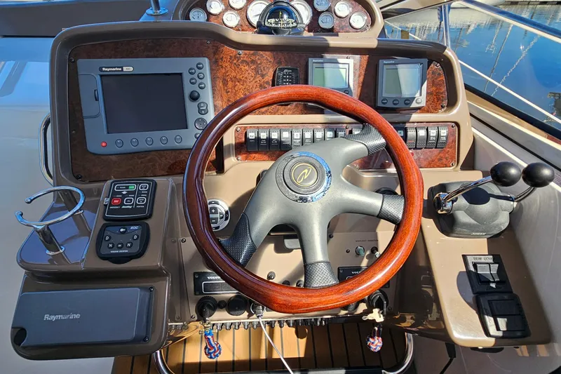 Slide: The Image of 2005 Regal Commodore 4260 helm with wood steering wheel and navigation controls. - 10