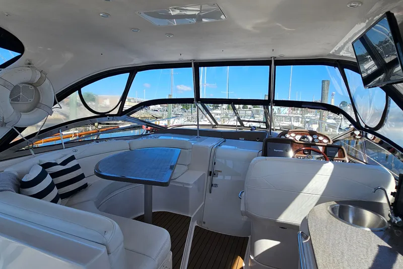 Slide: The Image of Luxurious 2005 Regal Commodore 4260 yacht interior with seating, table, and helm. - 17