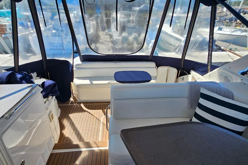 Slide: The Image of Interior of 2005 Regal Commodore 4260 yacht with seating and table, featuring nautical decor. - 18