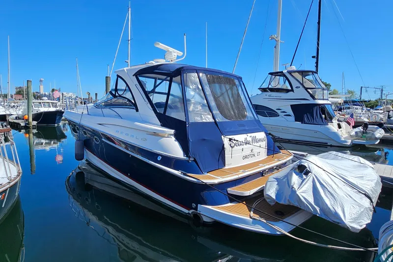 Slide: The Image of 2005 Regal Commodore 4260 yacht docked in a marina under clear blue skies. - 2