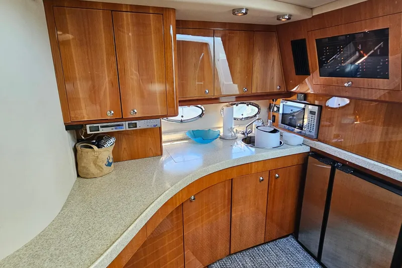 Slide: The Image of Luxurious 2005 Regal Commodore 4260 yacht kitchen with wood cabinets and modern appliances. - 21