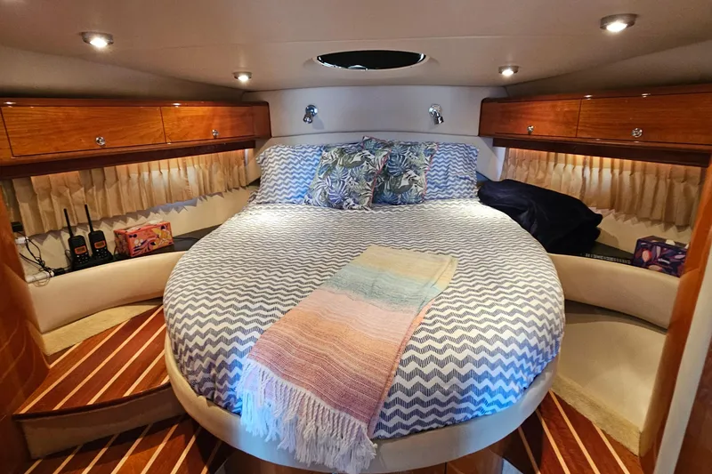 Slide: The Image of Luxurious 2005 Regal Commodore 4260 yacht cabin with cozy bed and elegant wood finishes. - 23