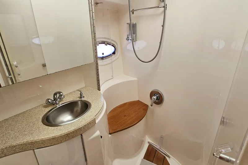Slide: The Image of Luxurious bathroom in 2005 Regal Commodore 4260 yacht with modern fixtures and porthole window. - 26