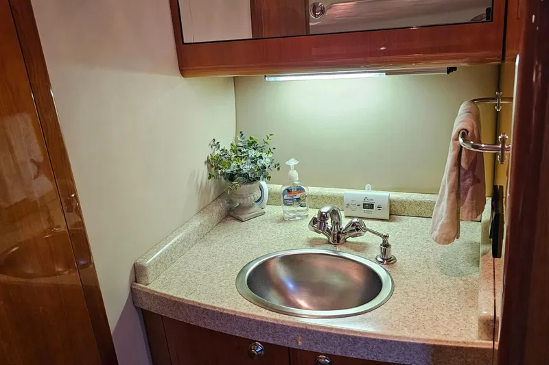 Slide: The Image of 2005 Regal Commodore 4260 yacht bathroom sink with countertop, faucet, and decor. - 30