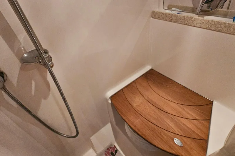 Slide: The Image of Shower area in 2005 Regal Commodore 4260 yacht with wooden seat and handheld showerhead. - 32
