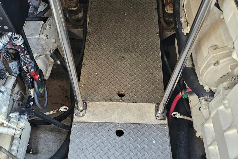 Slide: The Image of Engine room of 2005 Regal Commodore 4260 with metal flooring and visible wiring. - 44