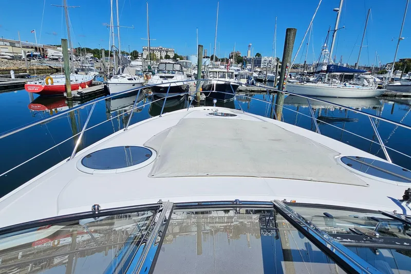 Slide: The Image of 2005 Regal Commodore 4260 yacht docked in a marina with clear blue skies. - 45
