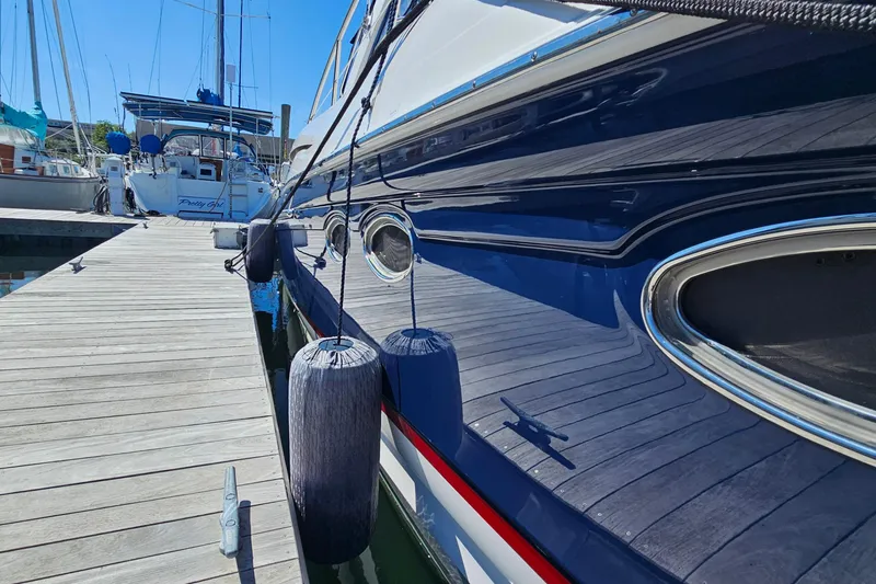Slide: The Image of 2005 Regal Commodore 4260 yacht docked with fenders, reflecting sunlight. - 6