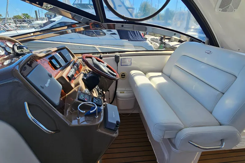 Slide: The Image of 2005 Regal Commodore 4260 yacht cockpit with white seating and modern controls. - 9