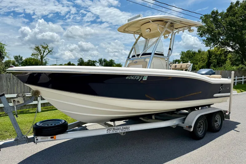Slide: The Image of 2008 Scout 222 Sportfish boat on trailer, parked outdoors under a cloudy sky. - 1