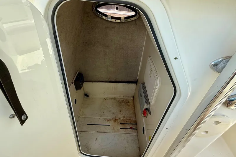 Slide: The Image of 2008 Scout 222 Sportfish boat interior storage compartment with hatch and porthole. - 13