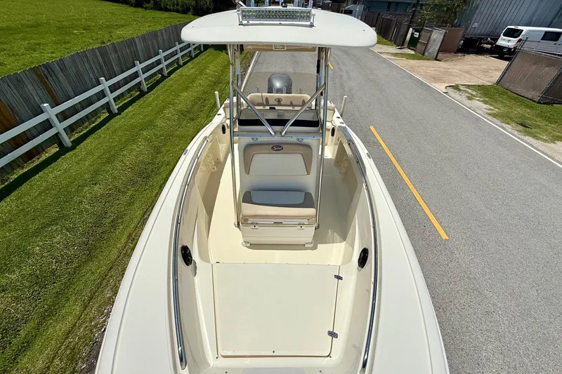 Slide: The Image of 2008 Scout 222 Sportfish boat on road, top view, near green lawn and fence. - 16