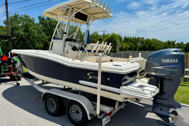 Slide: The Image of 2008 Scout 222 Sportfish boat with Yamaha engine on trailer, parked outdoors. - 2
