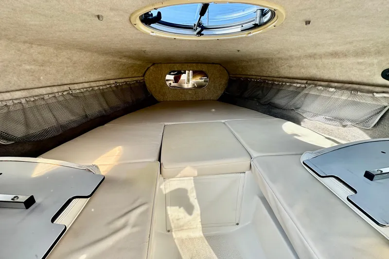 Slide: The Image of Interior cabin of 2010 Stingray 205 CS/CX boat with beige upholstery and storage nets. - 14