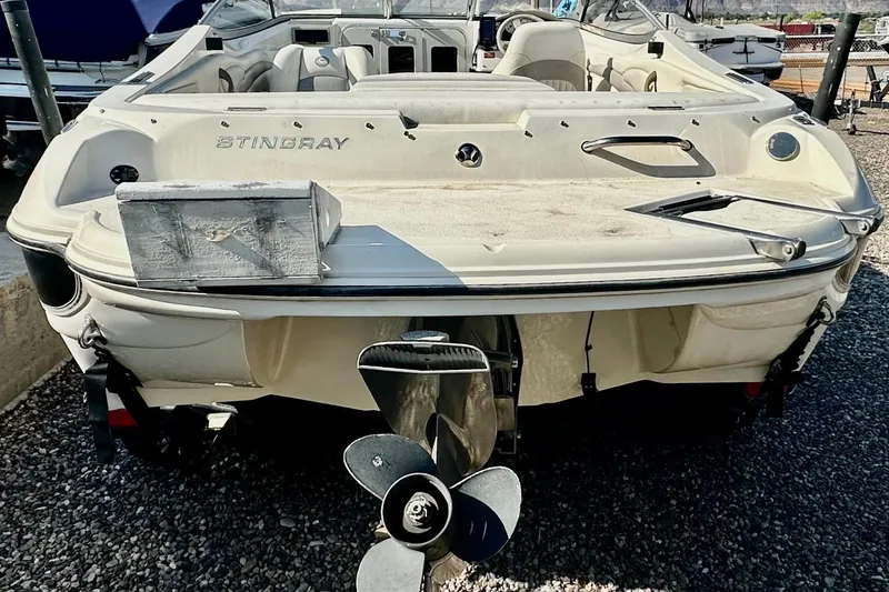Slide: The Image of 2010 Stingray 205 CS/CX boat, rear view with propeller, parked on gravel. - 4