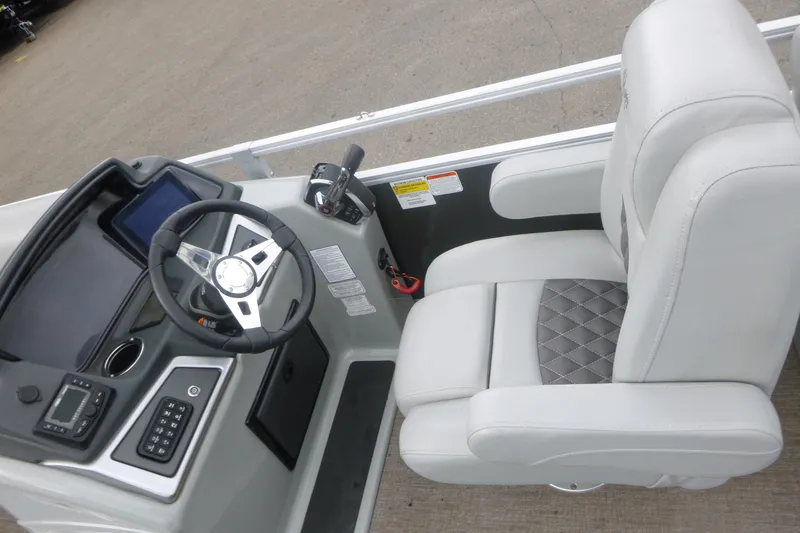 Slide: The Image of 2024 Ranger Reata 243C boat cockpit with steering wheel and plush captain's chair. - 6