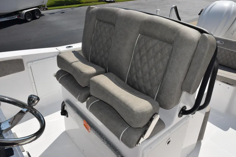 Slide: The Image of 2026 Sea Hunt Ultra 275 SE boat seating with gray cushioned upholstery and steering wheel. - 13