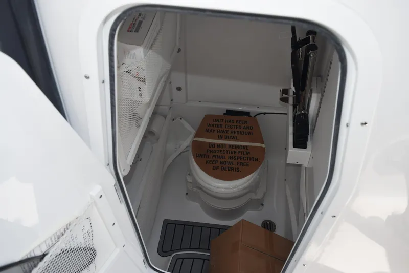 Slide: The Image of Interior of 2026 Sea Hunt Ultra 275 SE boat, featuring a compact bathroom. - 22