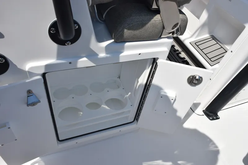 Slide: The Image of Open storage compartment on 2026 Sea Hunt Ultra 275 SE boat, featuring cup holders. - 29