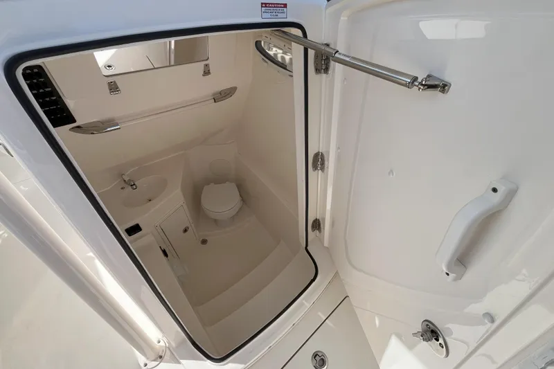 Slide: The Image of 2019 Cobia 277 Center Console boat interior bathroom with sink and toilet. - 14