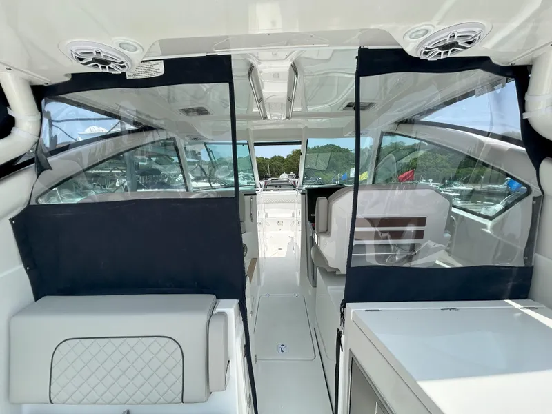 Slide: The Image of 2026 Pursuit DC 326 boat interior with seating and clear enclosures. - 12